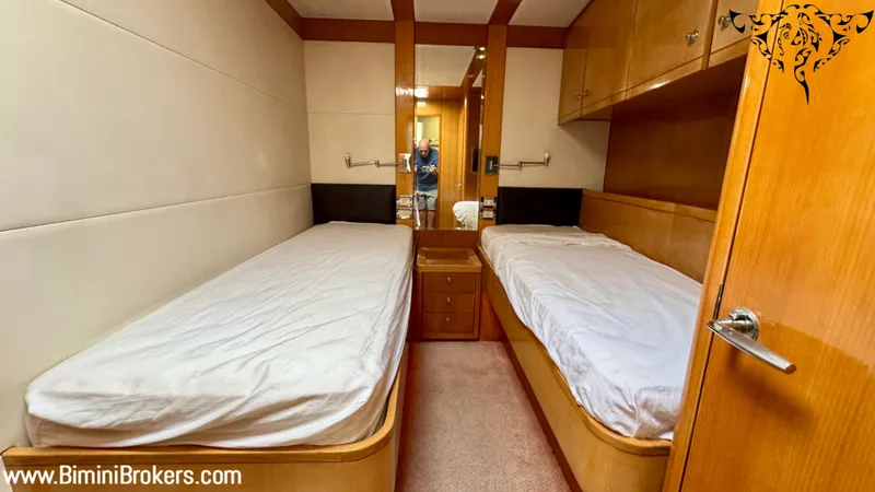  Yacht Photos Pics Twin cabin interior of 2011 Bertram 800 yacht with wooden finishes and white bedding.