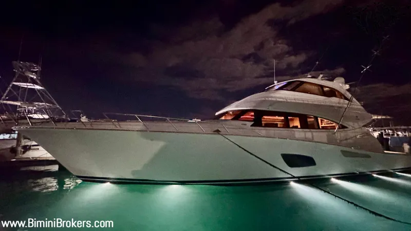 Yacht Photos Pics Luxurious 2011 Bertram 800 yacht illuminated at night, docked in serene waters.