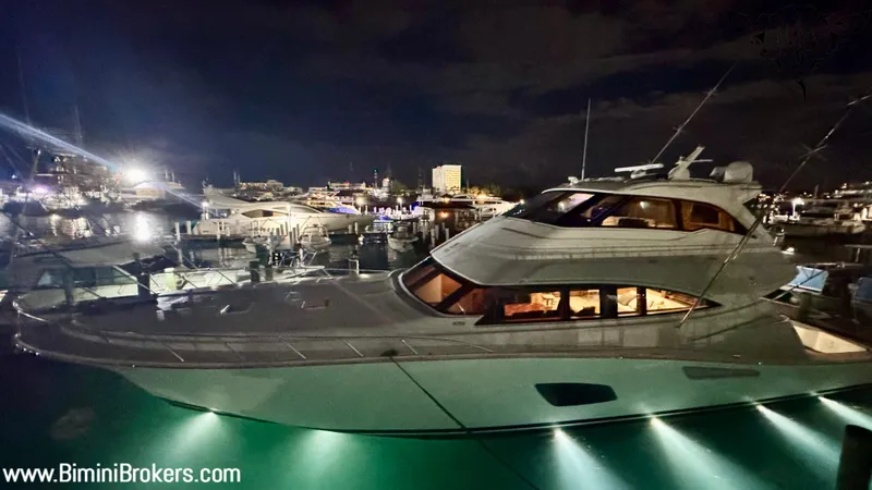  Yacht Photos Pics Luxurious 2011 Bertram 800 yacht illuminated at night in a marina setting.