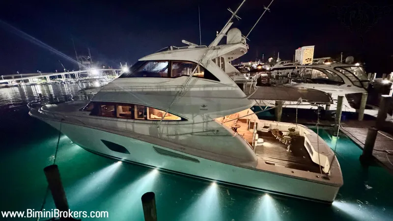  Yacht Photos Pics Luxurious 2011 Bertram 800 yacht illuminated at night in a marina setting.