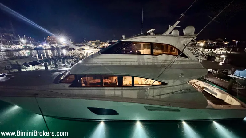  Yacht Photos Pics Luxurious 2011 Bertram 800 yacht docked at night, illuminated with interior lights.