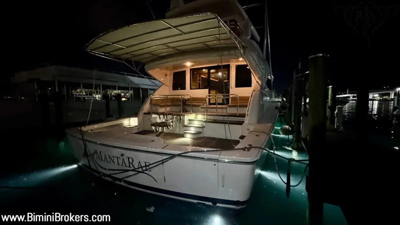  Yacht Photos Pics Luxury Bertram 800 yacht docked at night, illuminated with underwater lights.