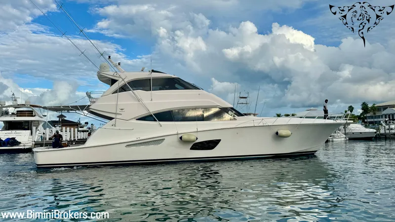  Yacht Photos Pics Luxury Bertram 800 yacht, 2011 model, cruising in a marina under a cloudy sky.