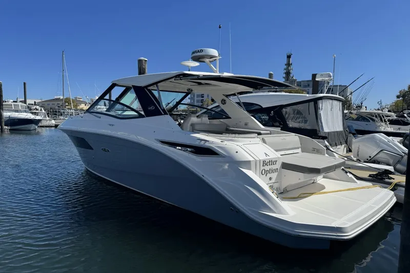  Yacht Photos Pics 2023 Sea Ray 320 Sundancer yacht docked in a marina under clear blue skies.