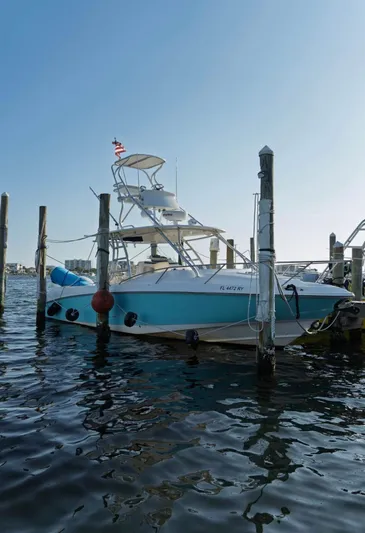  Yacht Photos Pics 2006 Boston Whaler 320 Outrage Cuddy Cabin docked in a marina, clear sky background.
