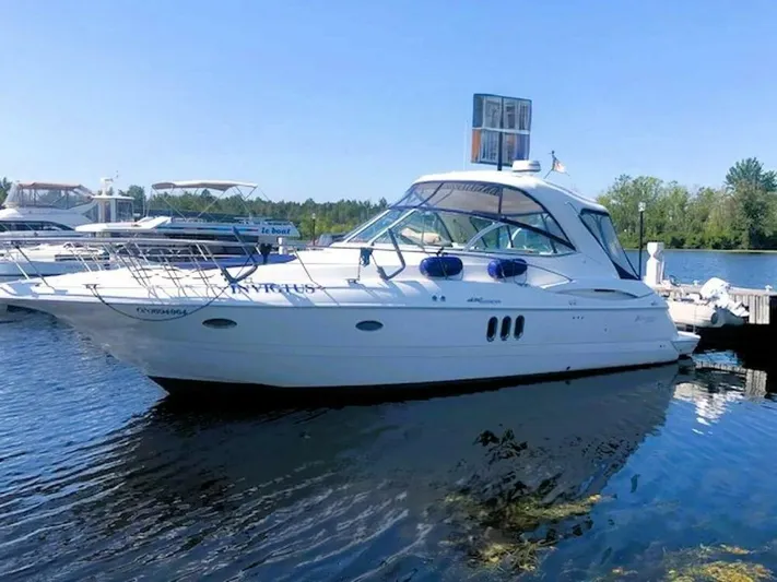  Yacht Photos Pics 2006 Cruisers Yachts 420 Express docked on a sunny day, reflecting on calm water.