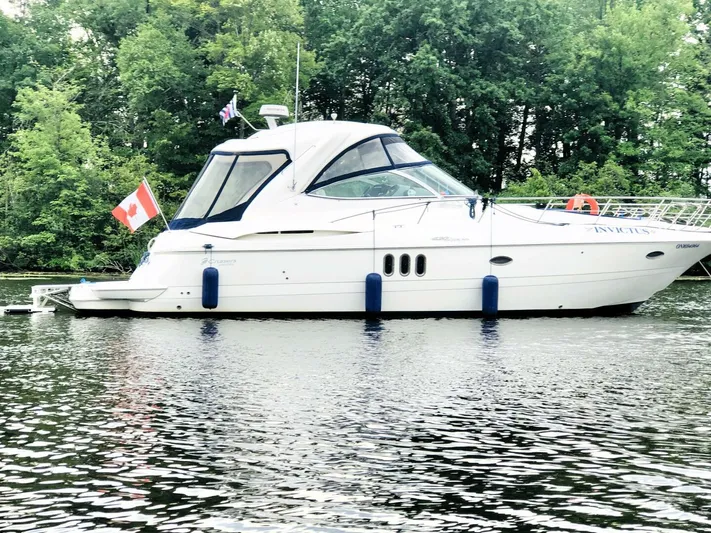  Yacht Photos Pics 2006 Cruisers Yachts 420 Express on water, Canadian flag, lush green background.
