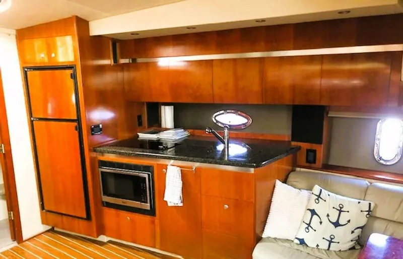  Yacht Photos Pics 2006 Cruisers Yachts 420 Express interior with wooden cabinetry, kitchenette, and nautical-themed decor.