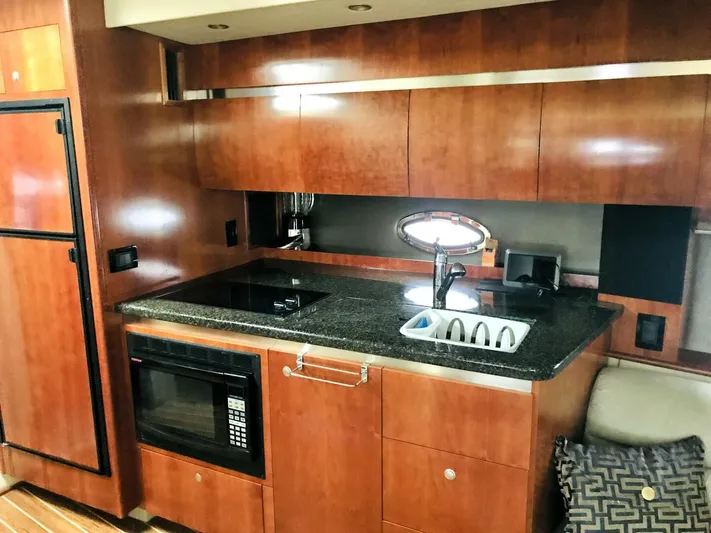  Yacht Photos Pics 2006 Cruisers Yachts 420 Express kitchen with wood cabinetry, microwave, and sink.