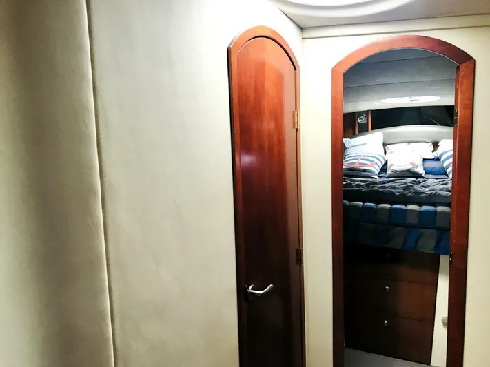  Yacht Photos Pics Interior of 2006 Cruisers Yachts 420 Express, featuring a cozy cabin with wooden door and mirror.