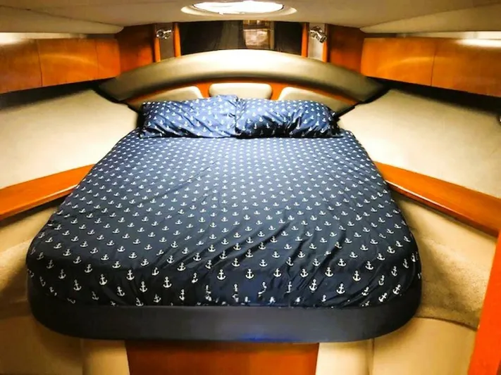  Yacht Photos Pics Luxurious cabin interior of 2006 Cruisers Yachts 420 Express with anchor-patterned bedding.