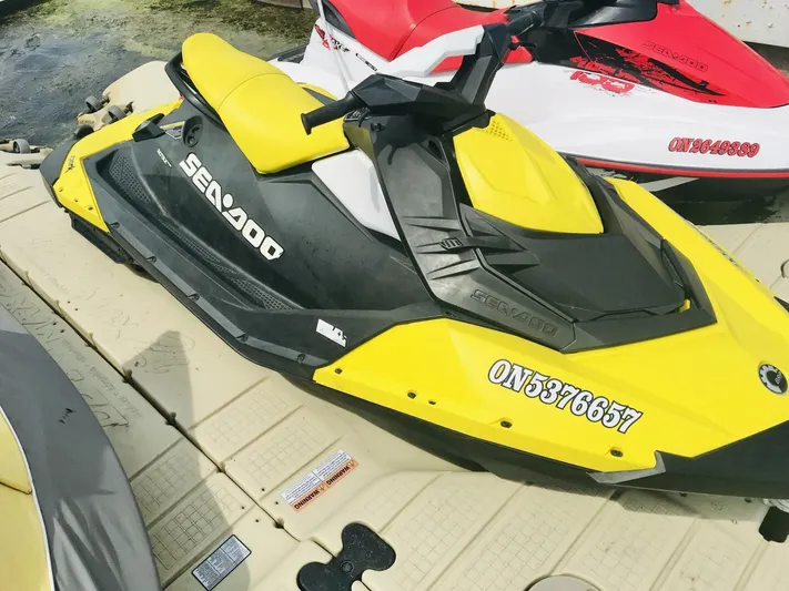  Yacht Photos Pics Yellow Sea-Doo jet ski on dock, alongside a red and white jet ski.