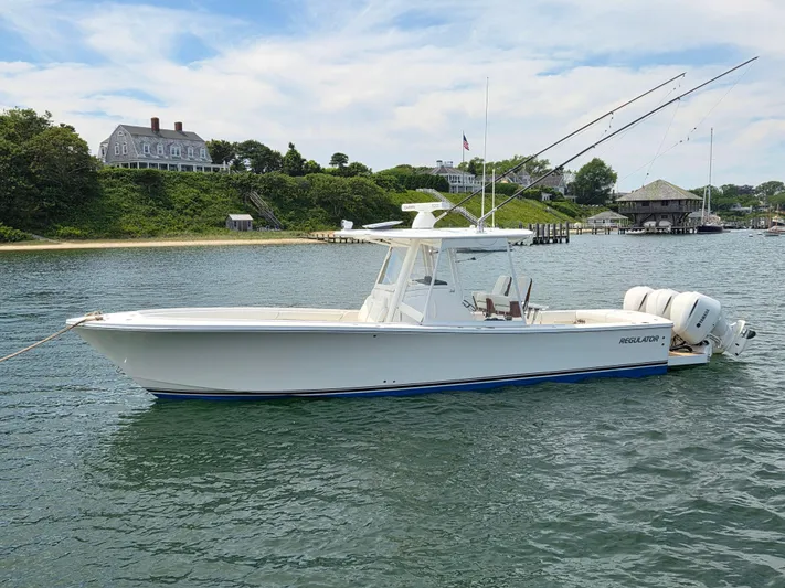 Hi Yacht Photos Pics 2020 Regulator 34 Center Console boat on calm water near coastal homes.