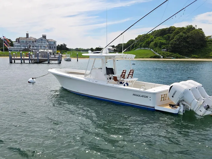 Hi Yacht Photos Pics 2020 Regulator 34 Center Console boat docked near a coastal mansion.