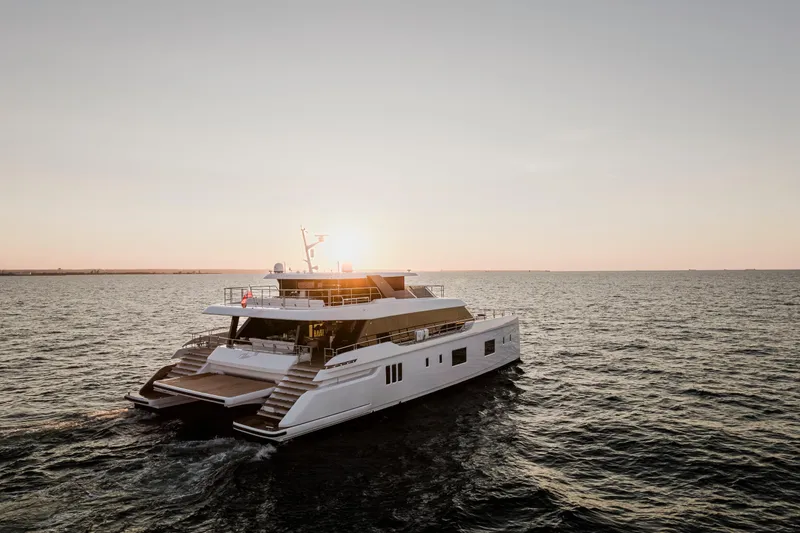  Yacht Photos Pics Luxurious 2026 Sunreef 100 Power yacht cruising at sunset on open sea.