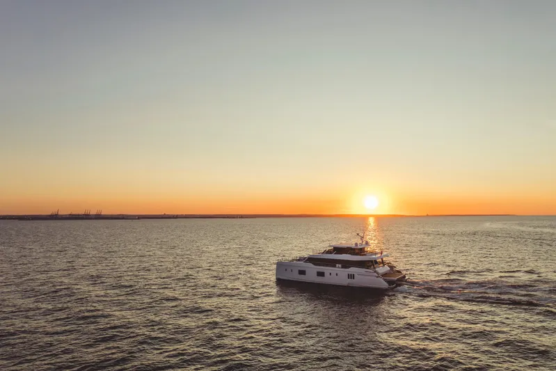  Yacht Photos Pics 2026 Sunreef 100 Power yacht cruising at sunset on open sea.