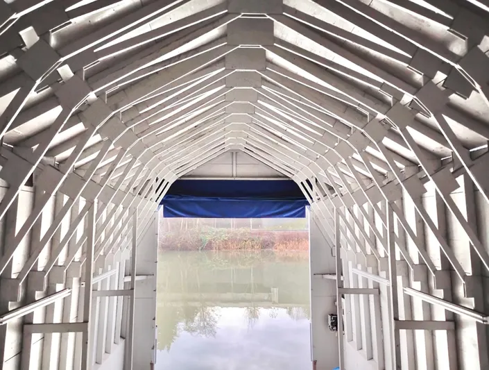  Yacht Photos Pics Interior view of a custom boathouse, showcasing wooden beams and a serene water reflection.