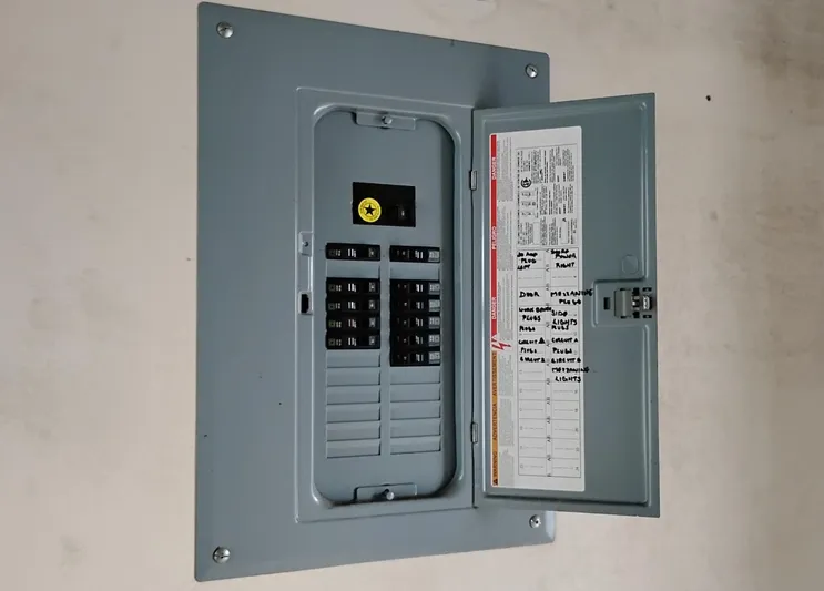  Yacht Photos Pics Electrical panel with open door, labeled circuits, and visible breakers in a custom boathouse.