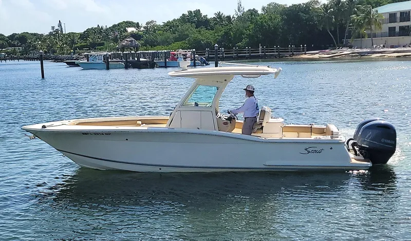  Yacht Photos Pics 2018 Scout 275 LXF boat on calm water with a person at the helm.