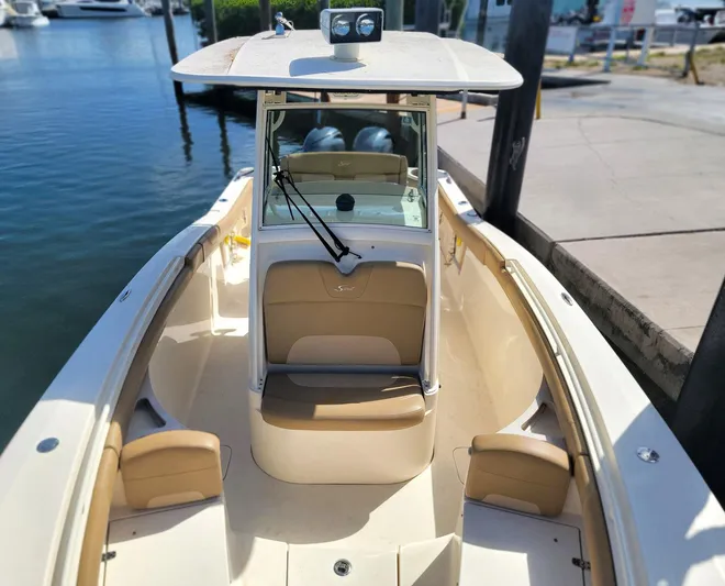  Yacht Photos Pics 2018 Scout 275 LXF boat docked at marina, featuring beige seating and console.