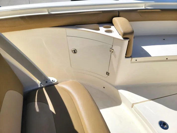 Yacht Photos Pics Interior view of 2018 Scout 275 LXF boat, featuring tan seating and storage compartment.