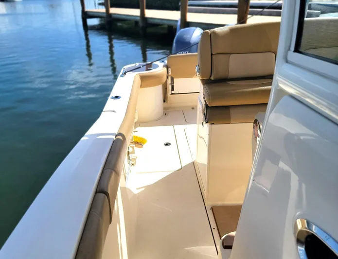  Yacht Photos Pics 2018 Scout 275 LXF boat interior with seating, docked by calm water.