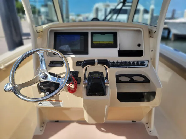  Yacht Photos Pics 2018 Scout 275 LXF boat dashboard with steering wheel and control panel.