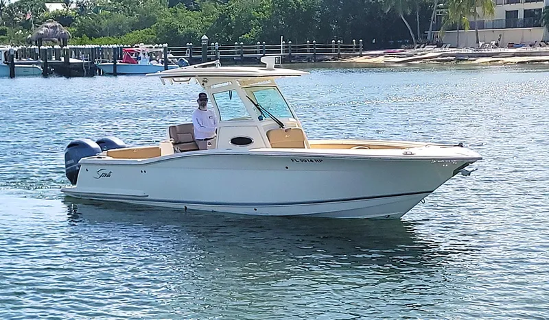  Yacht Photos Pics 2018 Scout 275 LXF boat cruising on a sunny day near a dock.