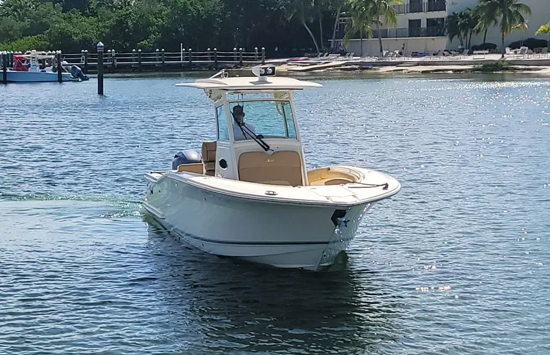  Yacht Photos Pics 2018 Scout 275 LXF boat cruising on a sunny day near a tropical shoreline.