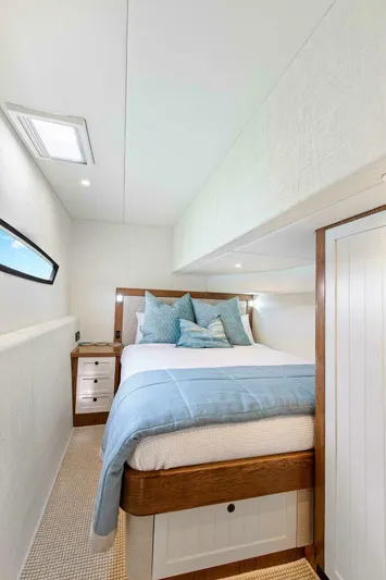 "the Keys" Yacht Photos Pics Luxurious bedroom interior on 2021 Valder Yachts Powercat, featuring cozy bedding and elegant wood accents.