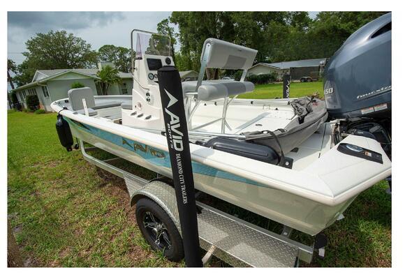 Avid 21 Fusion 2022 boat on trailer, parked on grass, with Yamaha outboard motor.