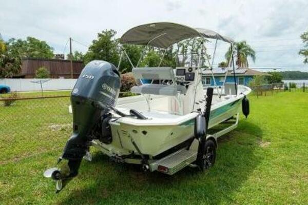 Avid 21 Fusion 2022 boat with Yamaha outboard motor on grassy yard.