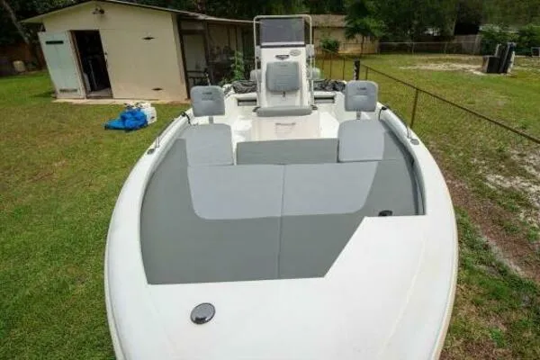 2022 Avid 21 Fusion boat in a grassy yard, near a shed.