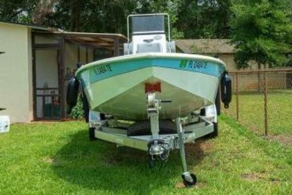 2022 Avid 21 Fusion boat on trailer, parked on grass near a house.