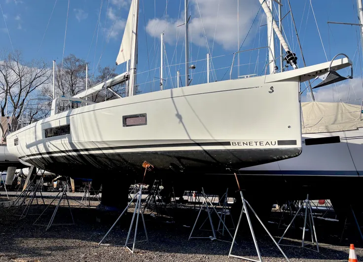 Betwixt Yacht Photos Pics 2022 Beneteau Oceanis 51.1 sailboat on stands, displayed outdoors under a clear sky.