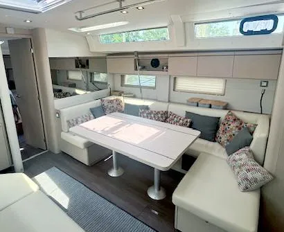 Betwixt Yacht Photos Pics Luxurious interior of 2022 Beneteau Oceanis 51.1 yacht with modern seating and dining area.