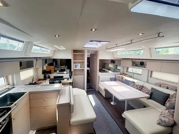 Betwixt Yacht Photos Pics Luxurious interior of 2022 Beneteau Oceanis 51.1 yacht with modern furnishings and ample natural light.
