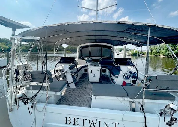 Betwixt Yacht Photos Pics 2022 Beneteau Oceanis 51.1 sailboat docked, featuring dual steering wheels and spacious cockpit.
