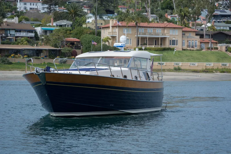 True Grit Yacht Photos Pics 2003 Apreamare 40 boat cruising near a coastal residential area.