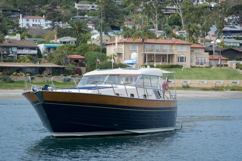 True Grit Yacht Photos Pics 2003 Apreamare 40 yacht on water, with luxurious waterfront homes in the background.