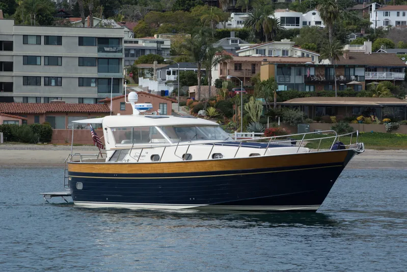 True Grit Yacht Photos Pics 2003 Apreamare 40 yacht cruising near coastal residential area.