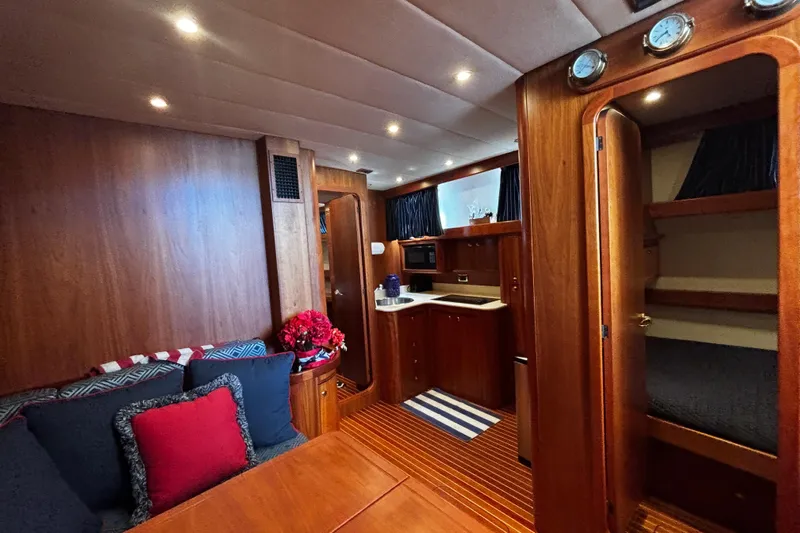 True Grit Yacht Photos Pics Luxurious 2003 Apreamare 40 yacht interior with wood finish, cozy seating, and compact kitchen.
