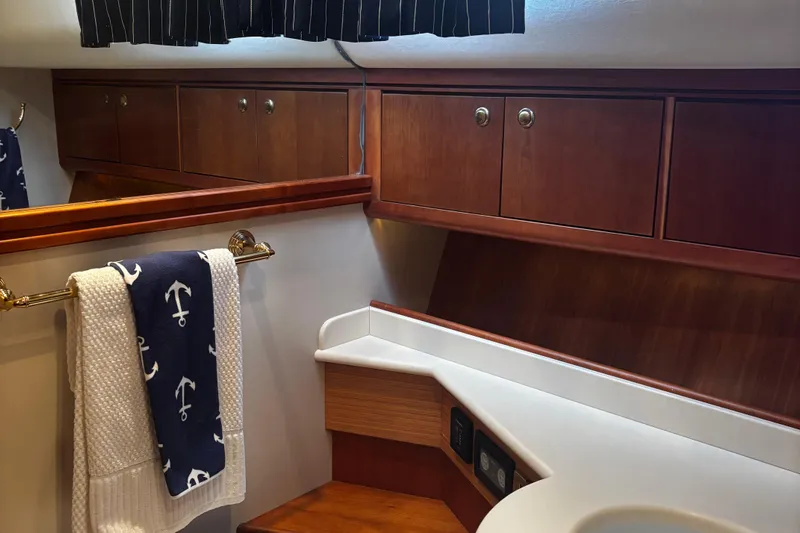True Grit Yacht Photos Pics Luxurious 2003 Apreamare 40 yacht bathroom with wooden cabinets and nautical-themed towels.