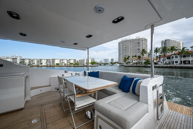 Liquid Asset Yacht Photos Pics Azimut 66 yacht deck with seating area, overlooking waterfront cityscape, 2020 model.