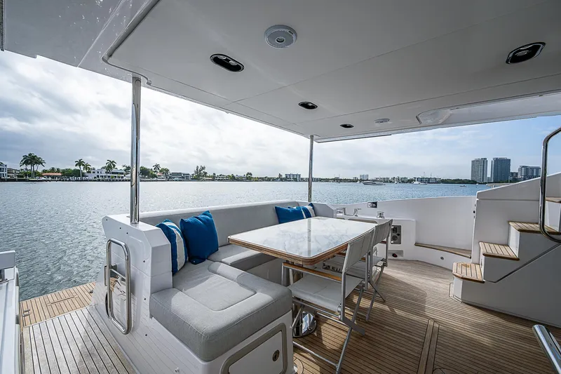 Liquid Asset Yacht Photos Pics Luxurious 2020 Azimut 66 yacht deck with seating, table, and scenic waterfront view.