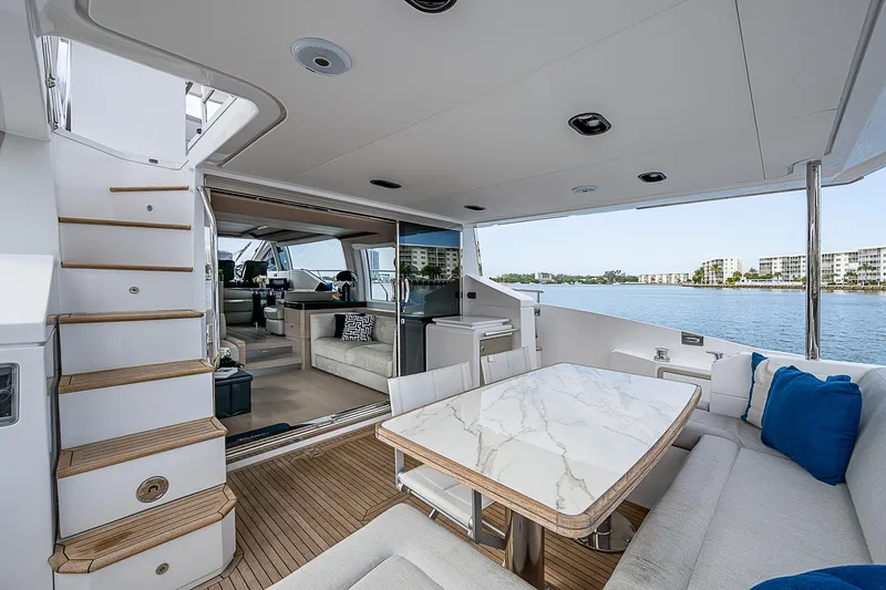 Liquid Asset Yacht Photos Pics Luxurious 2020 Azimut 66 yacht interior with elegant seating and marble table, overlooking serene waters.