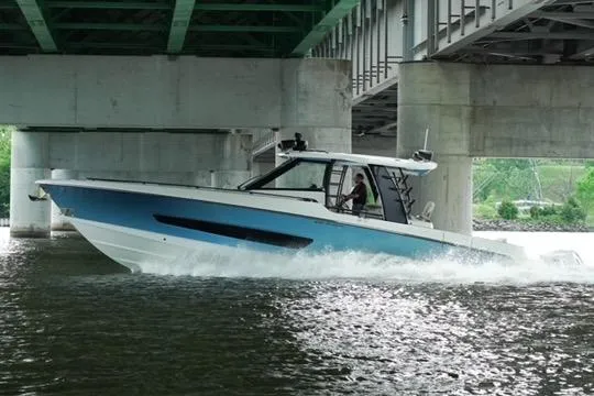 Fast Money Yacht Photos Pics 2021 Boston Whaler 420 Outrage cruising under a bridge on a river.