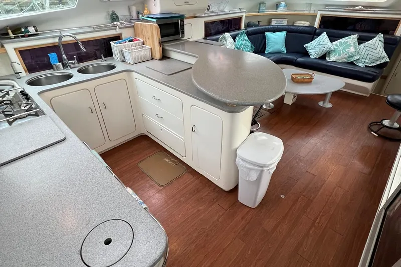 Seapaws Yacht Photos Pics 1996 Voyage Yachts 470 interior with kitchen and seating area, modern design, wooden flooring.