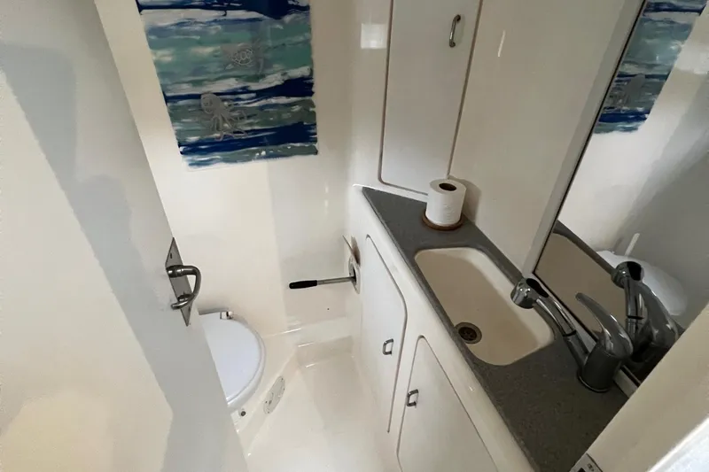 Seapaws Yacht Photos Pics Compact bathroom in a 1996 Voyage Yachts 470, featuring a sink, toilet, and storage cabinets.
