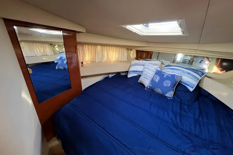 Jus A Lil' Yacht Photos Pics Luxurious cabin interior of 2003 Searay 380 yacht with blue bedding and decorative pillows.